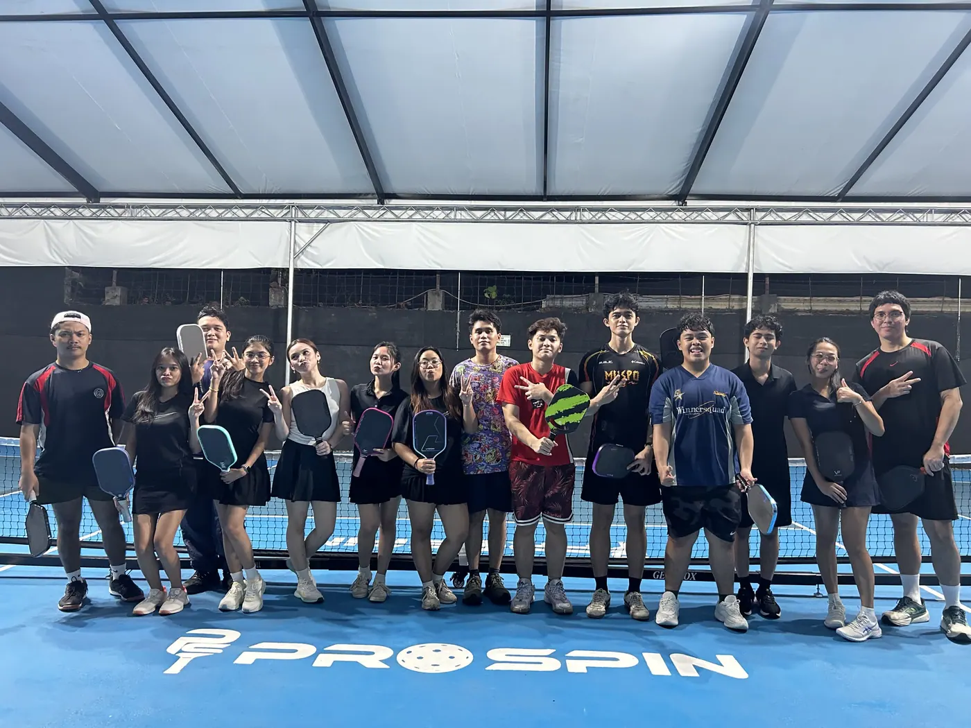 Pickleball group standing together beside the net after play