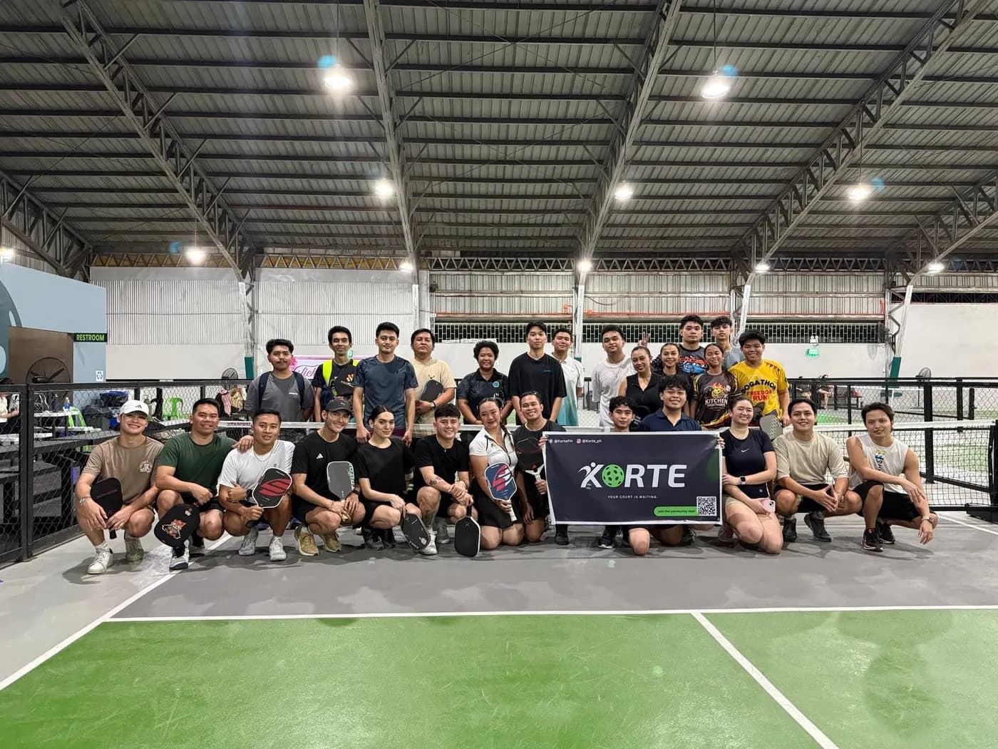 Players posing together with a Korte banner on court