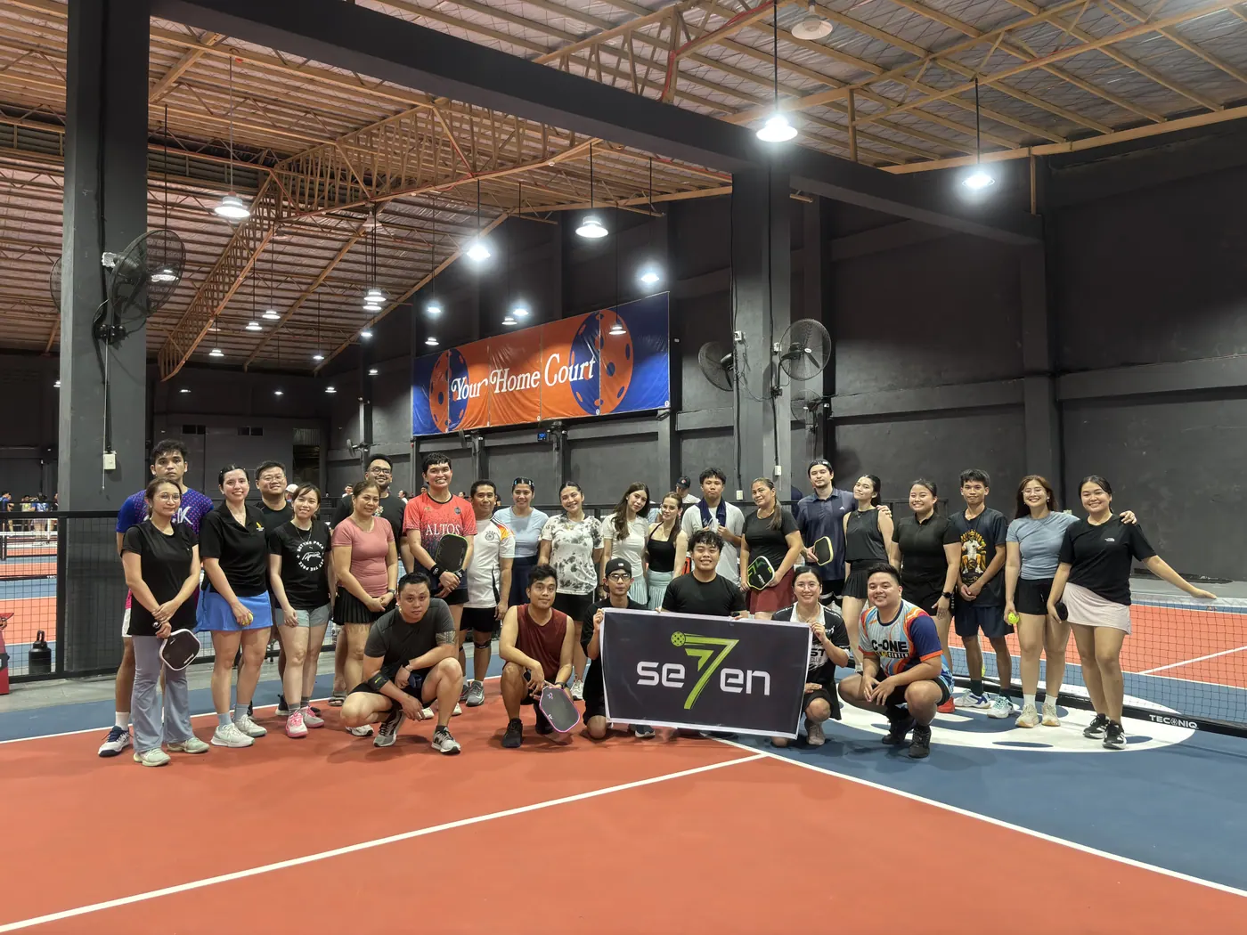 Players gathered on an orange court after a community session